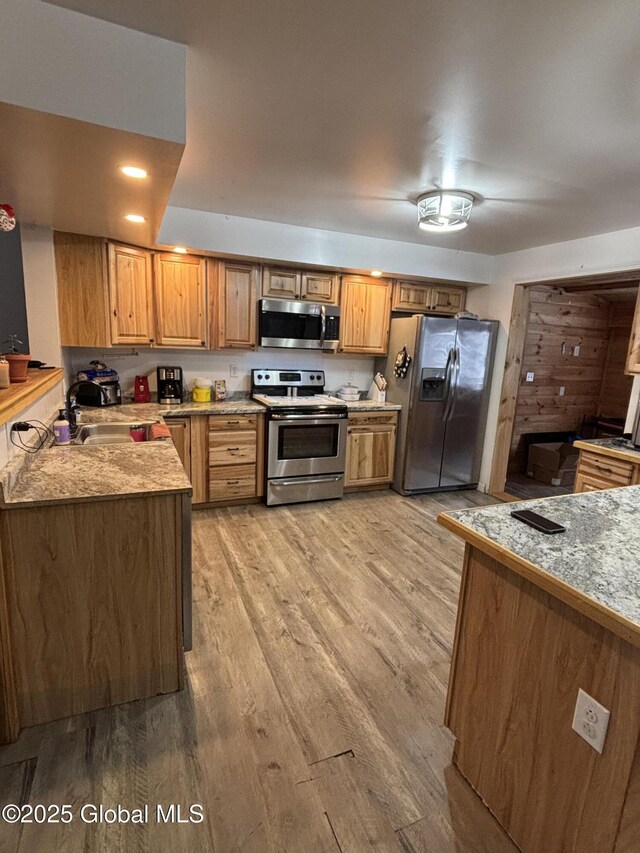 86 Reid St, Fort Plain, NY 13339 - kitchen featuring brown cabinets, a sink, light wood-style floors, appliances with stainless steel finishes, and light countertops