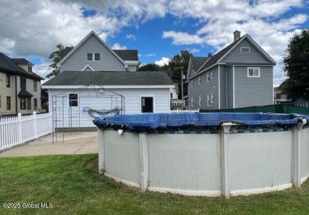 view of swimming pool with an outdoor structure and a lawn