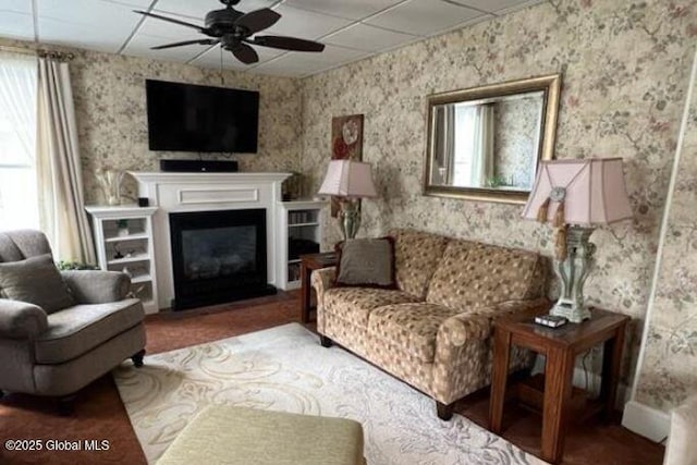 living room with plenty of natural light, ceiling fan, and a paneled ceiling