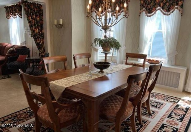 dining space with radiator and a notable chandelier