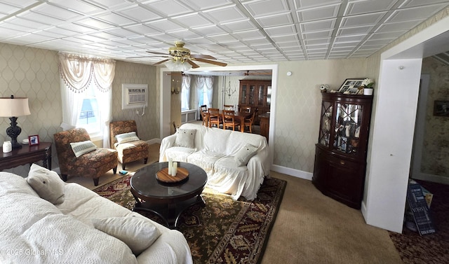 carpeted living room with ceiling fan and a wall mounted AC