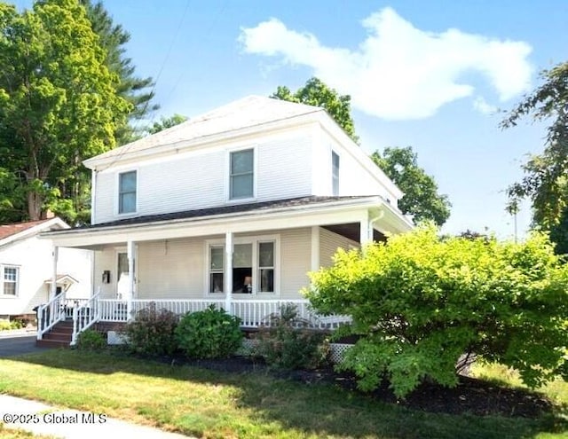 country-style home featuring a front yard and covered porch