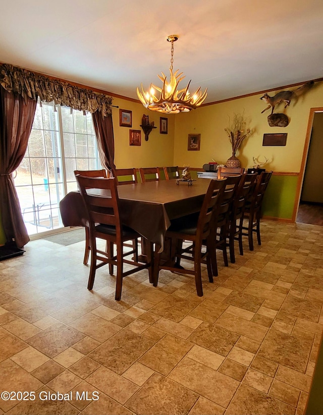 dining space with ornamental molding and a chandelier