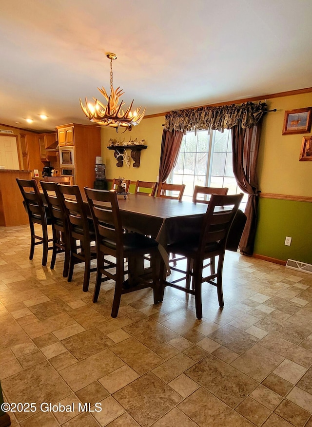 dining room featuring crown molding and a chandelier