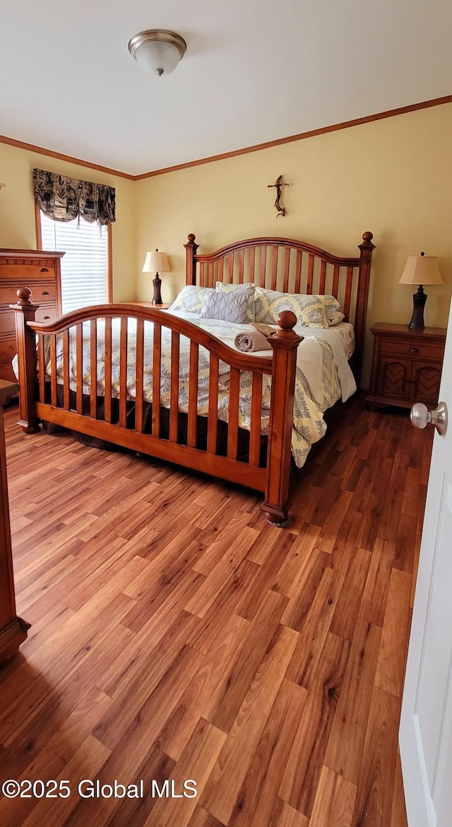 bedroom featuring wood-type flooring and crown molding
