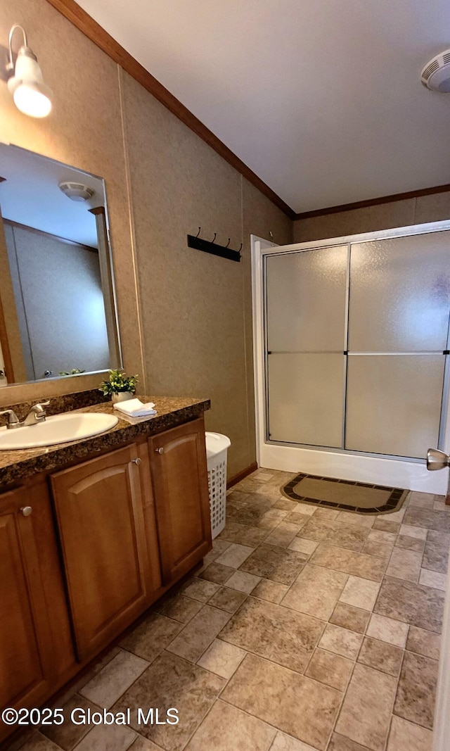 bathroom with ornamental molding, vaulted ceiling, vanity, and walk in shower