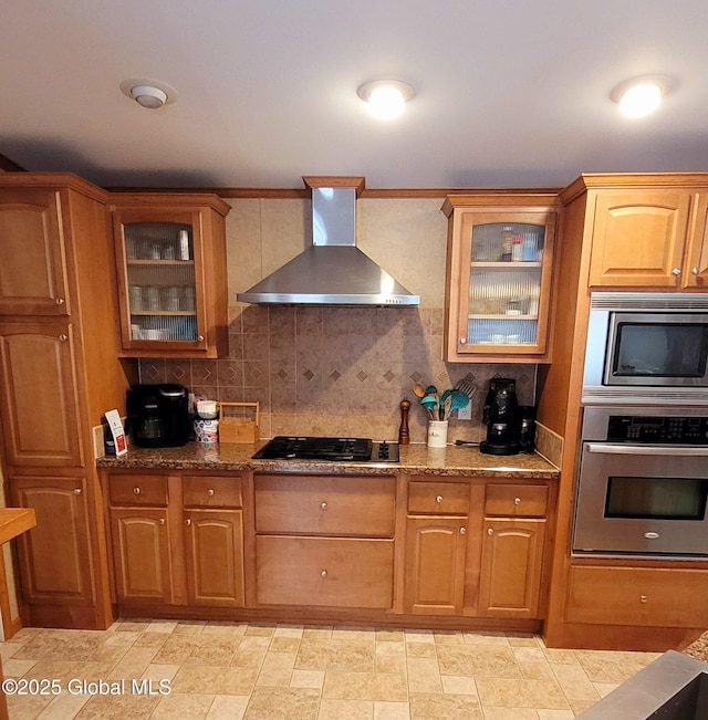 kitchen featuring stone counters, tasteful backsplash, appliances with stainless steel finishes, and wall chimney exhaust hood