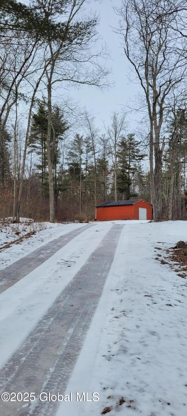 snowy yard with an outbuilding and a garage