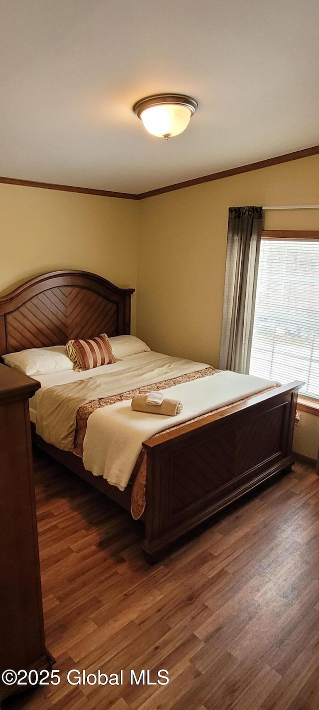 bedroom featuring ornamental molding and dark hardwood / wood-style flooring