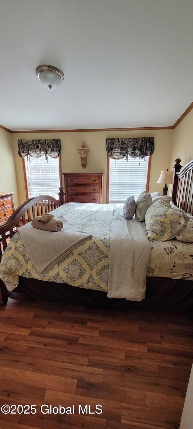 bedroom with crown molding and dark hardwood / wood-style flooring