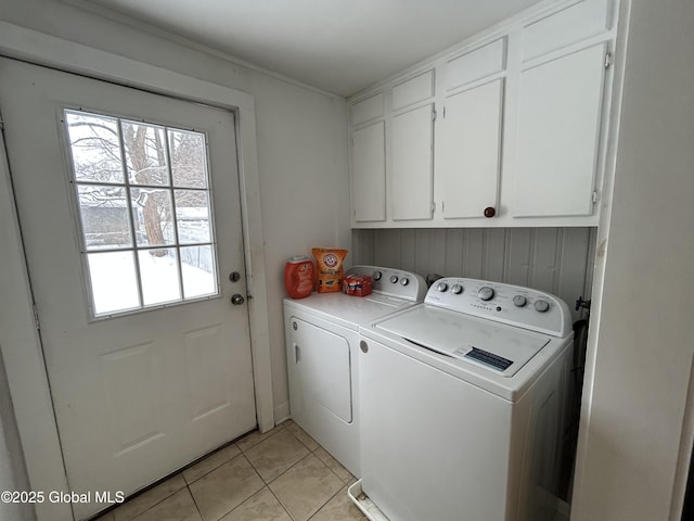 laundry area with cabinets, independent washer and dryer, and light tile patterned flooring