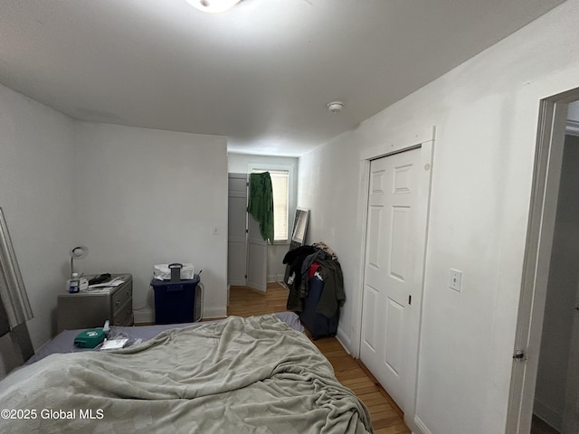 bedroom with light wood-type flooring and a closet