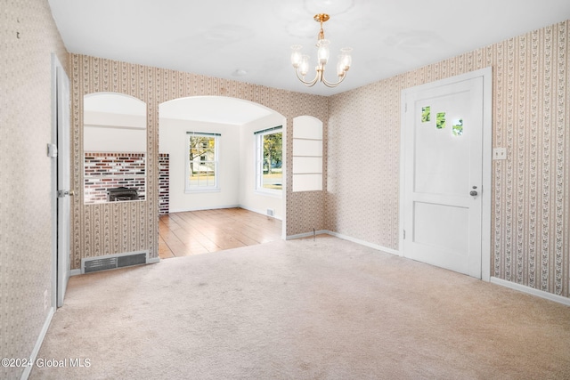 carpeted foyer entrance featuring a chandelier