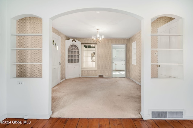 corridor featuring carpet flooring and a chandelier