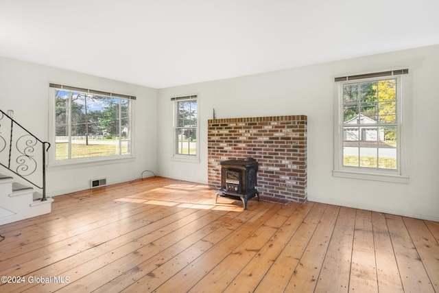 unfurnished living room with light hardwood / wood-style floors and a wood stove