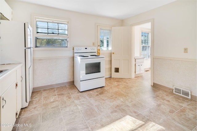 kitchen with white cabinetry and white appliances