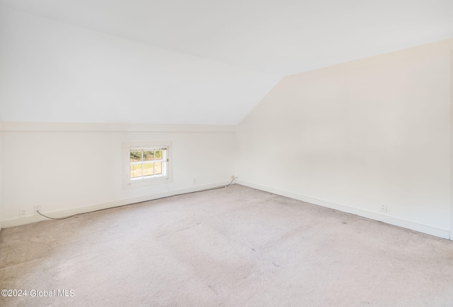 bonus room featuring vaulted ceiling and carpet flooring