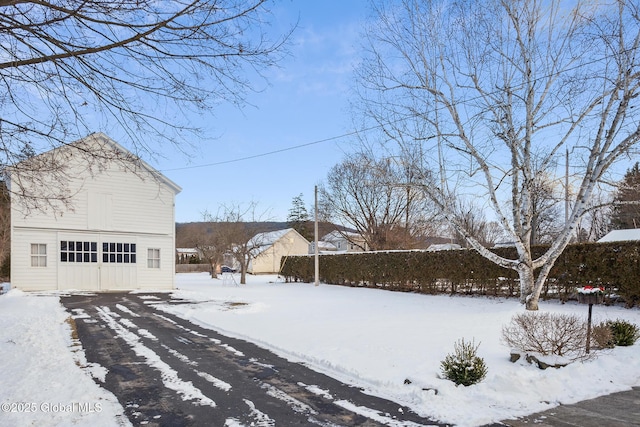 snowy yard featuring a garage