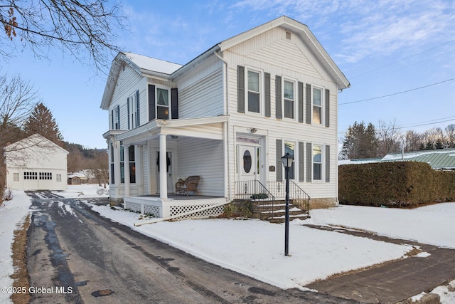 view of front facade featuring a garage, an outdoor structure, and a porch