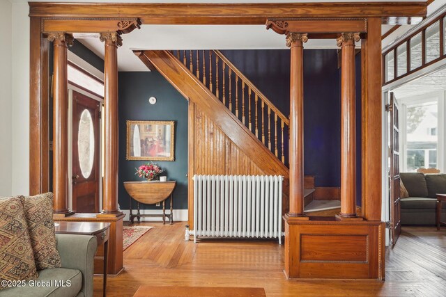 interior space with radiator, parquet flooring, and ornate columns