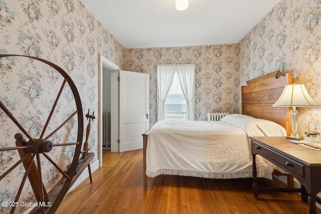 bedroom featuring radiator heating unit and wood-type flooring