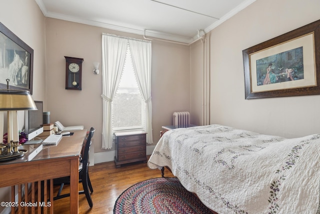 bedroom featuring radiator, wood-type flooring, and ornamental molding