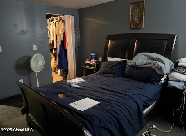 carpeted bedroom with a spacious closet and a closet