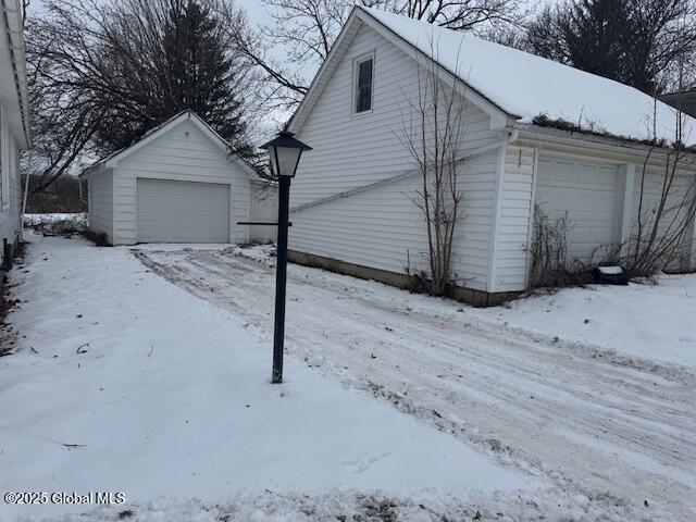 view of snowy exterior featuring a garage