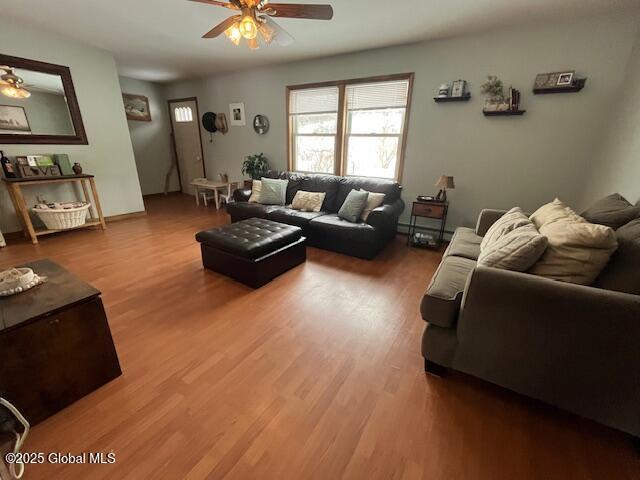 living room featuring wood-type flooring and ceiling fan