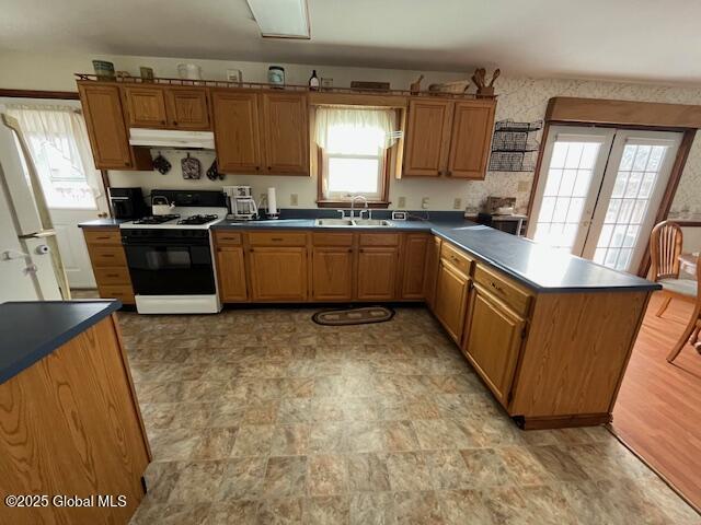 kitchen with white refrigerator, sink, and gas range oven