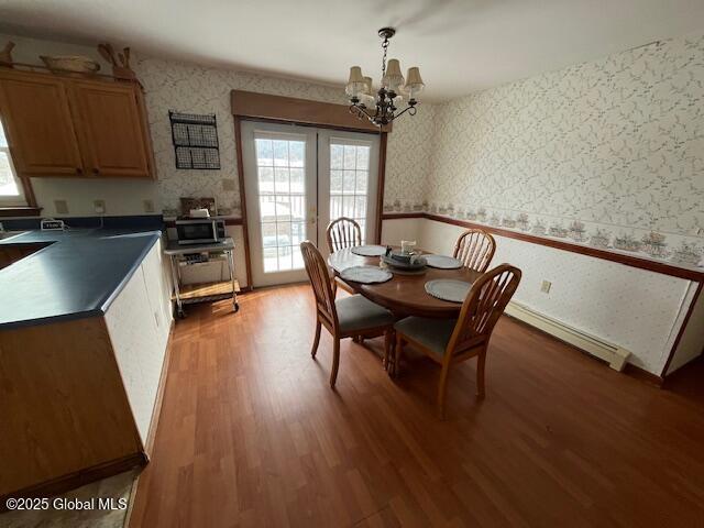 dining area featuring dark wood-type flooring, a notable chandelier, and baseboard heating