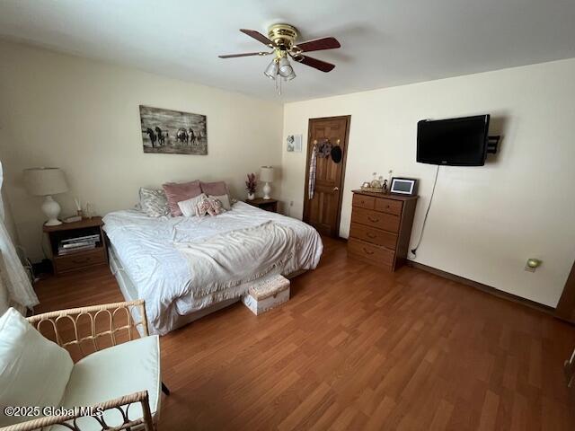 bedroom with dark hardwood / wood-style floors and ceiling fan