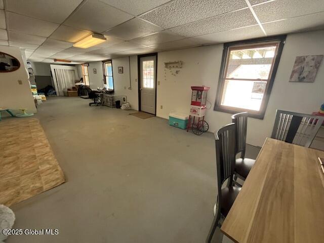 interior space featuring a wealth of natural light, concrete floors, and a paneled ceiling