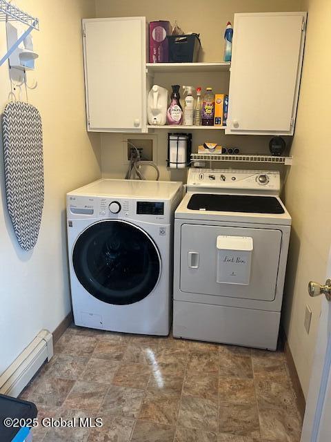 clothes washing area featuring cabinets, washing machine and dryer, and a baseboard radiator