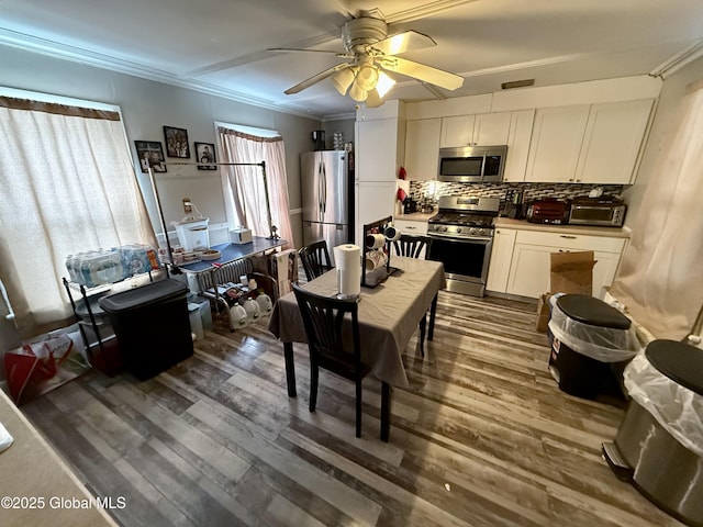 dining space with dark hardwood / wood-style flooring, ornamental molding, and ceiling fan