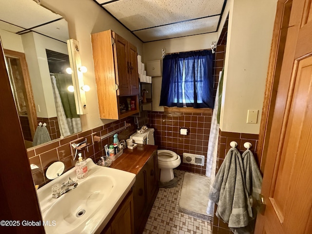 bathroom with vanity, tile walls, and toilet