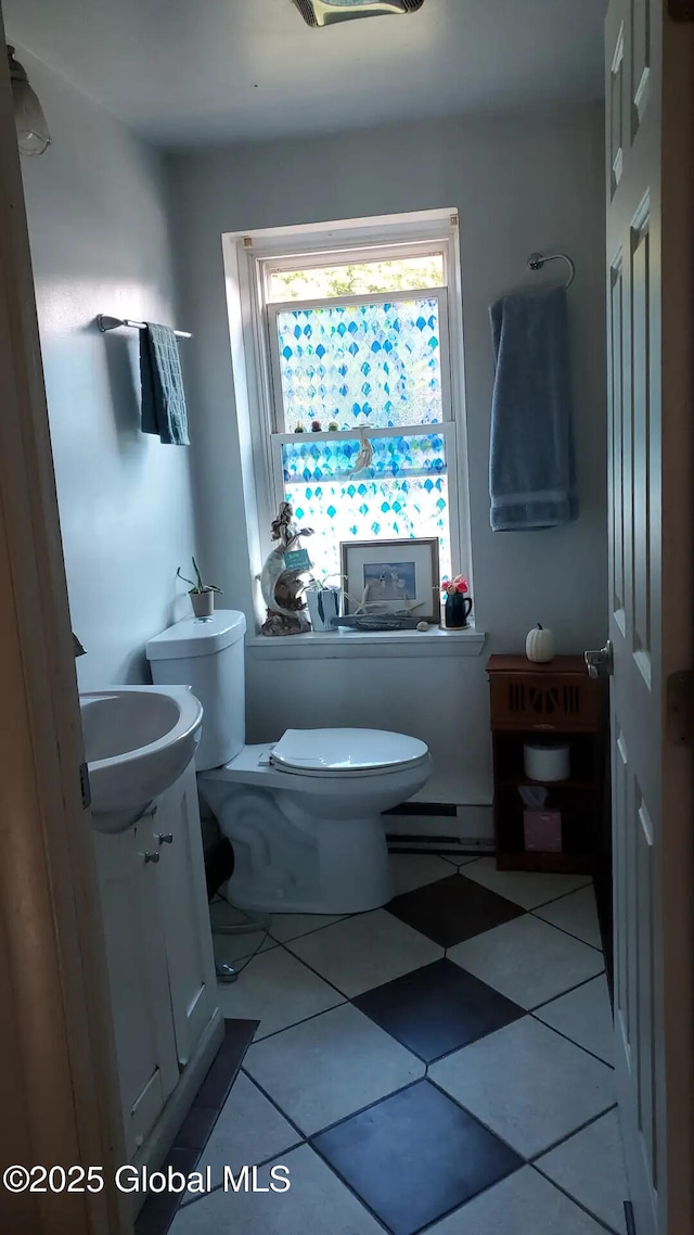 bathroom featuring vanity, a baseboard heating unit, and toilet