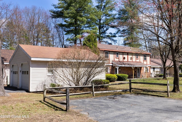 view of front of property featuring a front yard, an attached garage, and fence