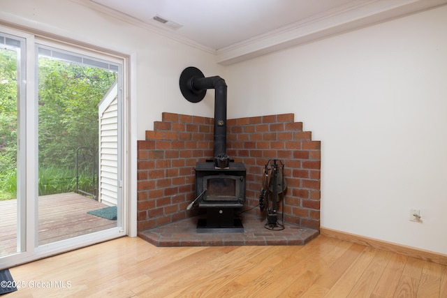26 Queens Way, Queensbury, NY 12804 - detailed view of wood finished floors, a wood stove, crown molding, and baseboards