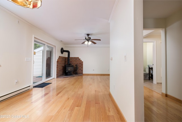 26 Queens Way, Queensbury, NY 12804 - unfurnished living room with a wood stove, baseboard heating, light wood-style floors, ceiling fan, and ornamental molding