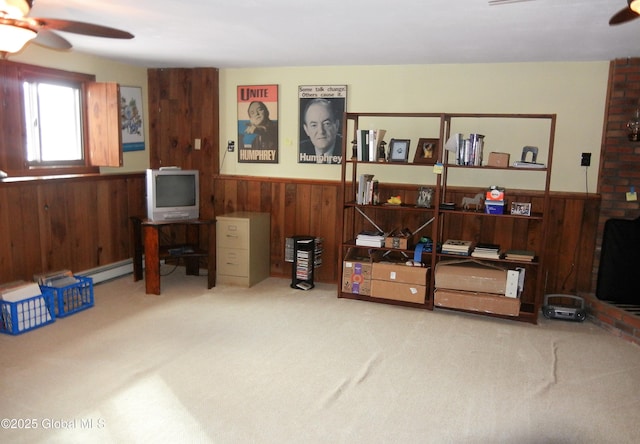 miscellaneous room with carpet floors, wooden walls, a baseboard radiator, and ceiling fan