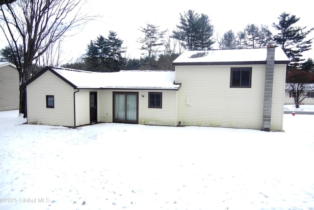 view of snow covered back of property