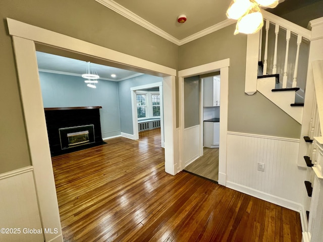 unfurnished living room with ornamental molding, dark hardwood / wood-style flooring, and radiator