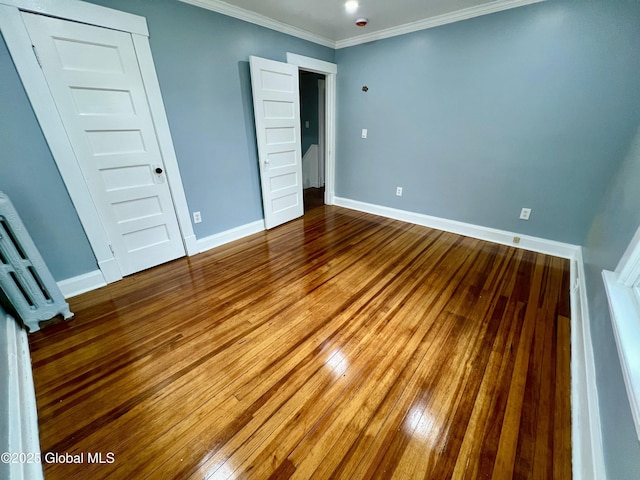 unfurnished bedroom featuring hardwood / wood-style floors and ornamental molding