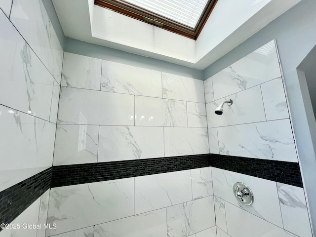 bathroom featuring a skylight and a tile shower