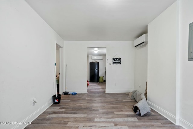 empty room featuring light hardwood / wood-style flooring and a wall unit AC