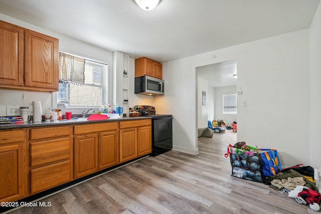 kitchen featuring sink, light hardwood / wood-style flooring, and black / electric stove