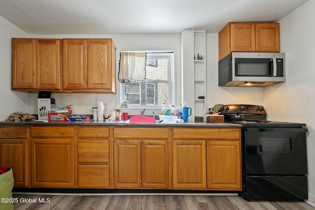 kitchen featuring black / electric stove, dark hardwood / wood-style flooring, and sink