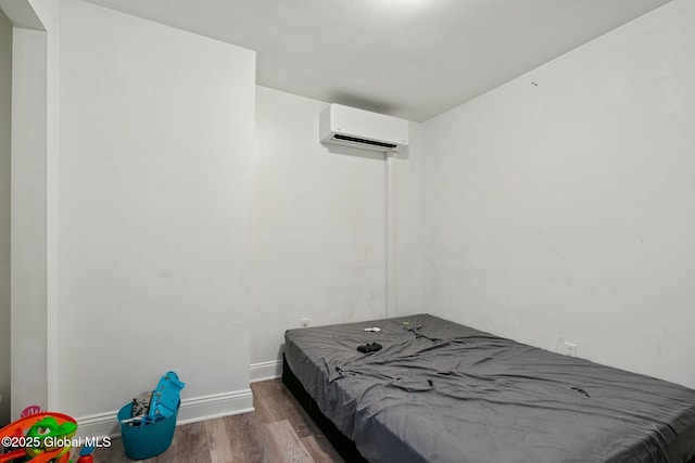 bedroom with wood-type flooring and an AC wall unit