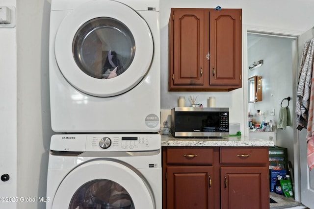 clothes washing area featuring stacked washer / dryer